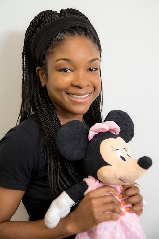 Ashley Leslie Program Director holding a Minnie Mouse plush toy.